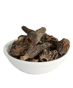A close-up of high-quality dried morel mushrooms in a white bowl.